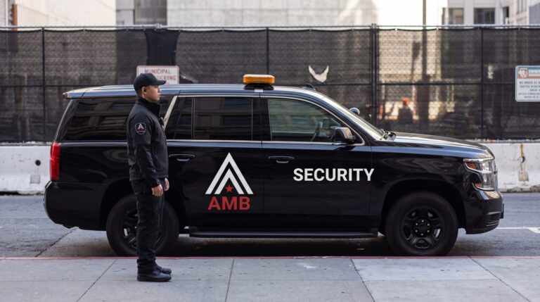 AMB Protective Services officer standing beside a marked patrol SUV outside a fenced San Francisco construction site.